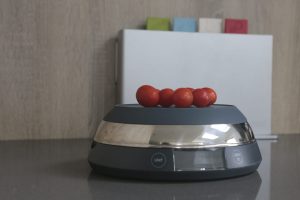 Joseph Joseph SwitchScale 2-in-1 Digital Scale with bowl facing downwards and cherry tomatoes being weighed on top