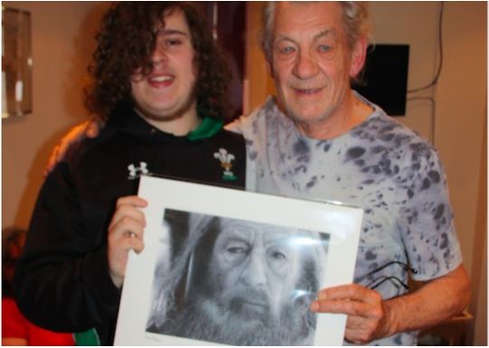 Chris Baker presenting one of his heroes, Ian McKellen, with his drawing of Gandalf.