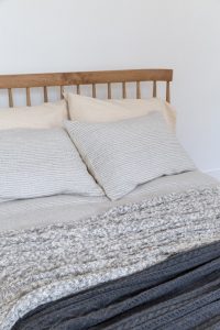 Cotton Cable Knit Natural/Grey Double 150cm x 200cm shown on a bed