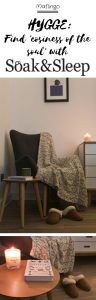 Hygge: The Danish secret of Happiness. Find 'cosiness of the soul' with Soak & Sleep with candles, cable knit cotton throw, cosy sheepskin slippers, a cosy armchair in a nook.