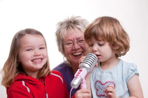 Grandma, ELdest and Youngest with youngest singing into a mic