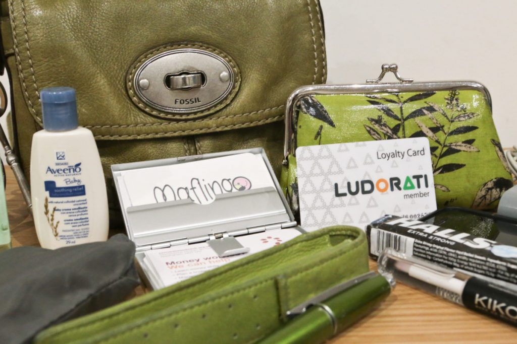 Close-up of my green Fossil handbag with Cross Edge pen and case, Green floral clasp purse, Moo business cards, Ludorati loyalty card, Halls cough sweets, Aveeno cream, Carrier bag