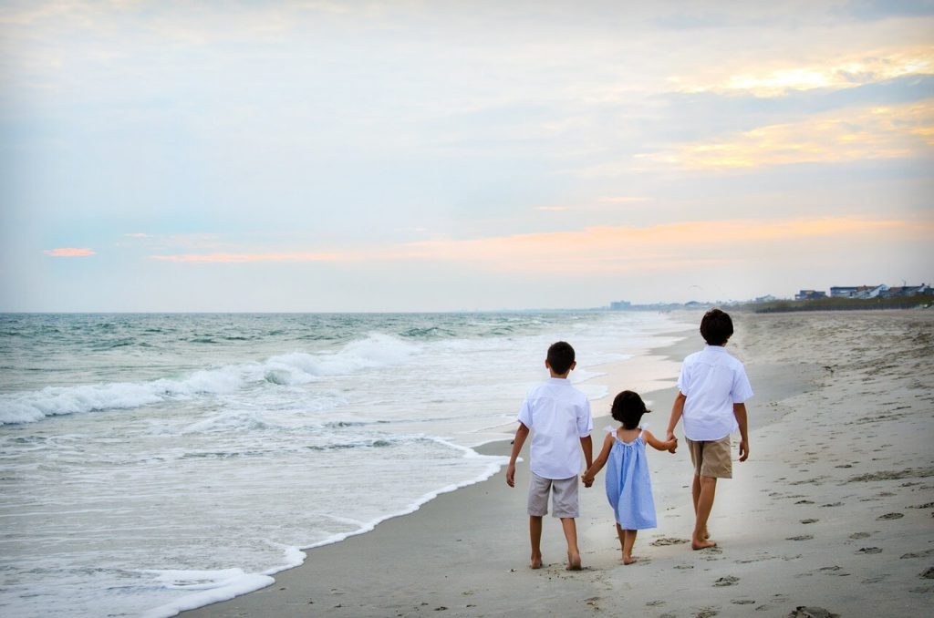 Children on a beach beside sea