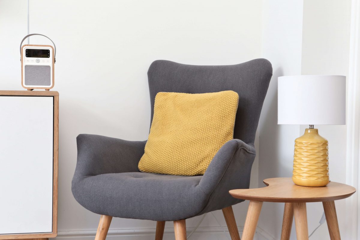 VQ Monty DAB Digital Radio with grey chair and orange cushion and lamp Scandi style